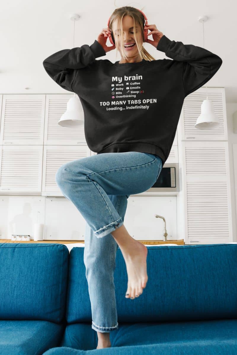 cozy stress relief sweater with a woman dancing on the sofa while listening music
