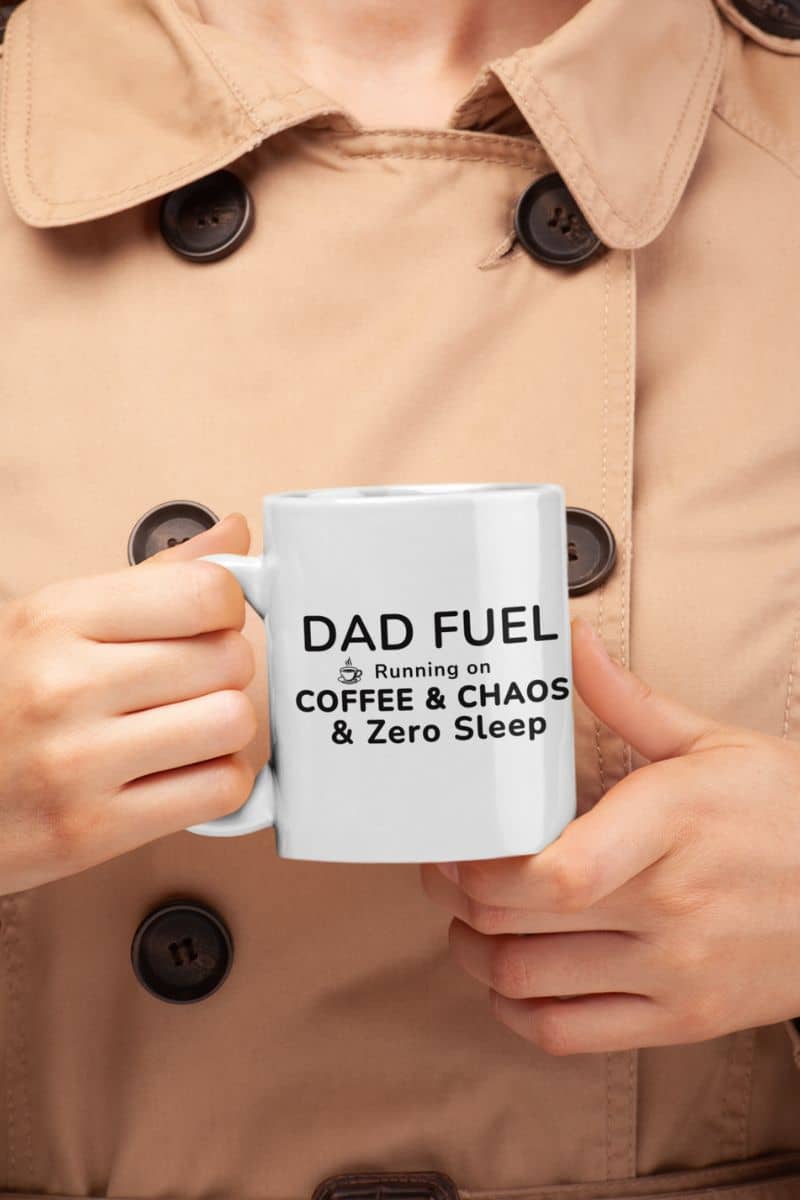dad coffee mugs with a person holding a mug with text 'DAD FUEL – Running on Coffee & Chaos & Zero Sleep' in a beige coat