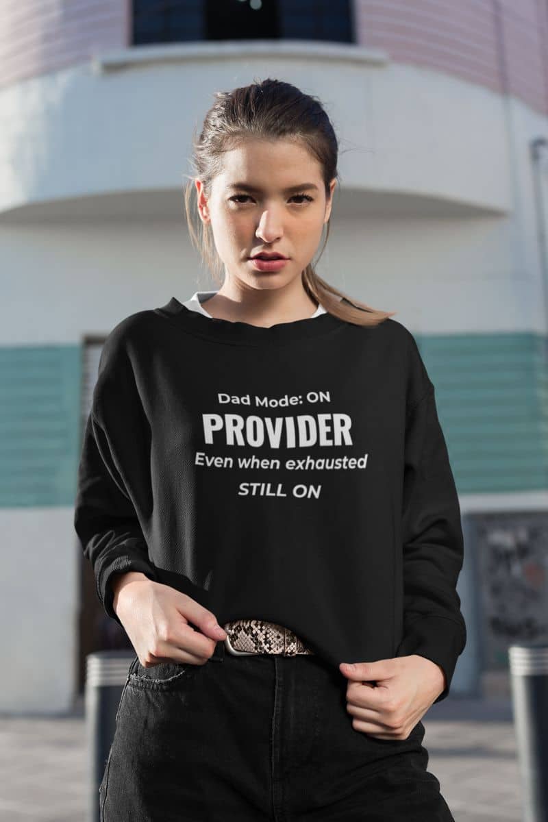 dad crewneck with a woman wearing a sweatshirt with text 'Dad Mode: On. Provider. Even when exhausted. Still on'
