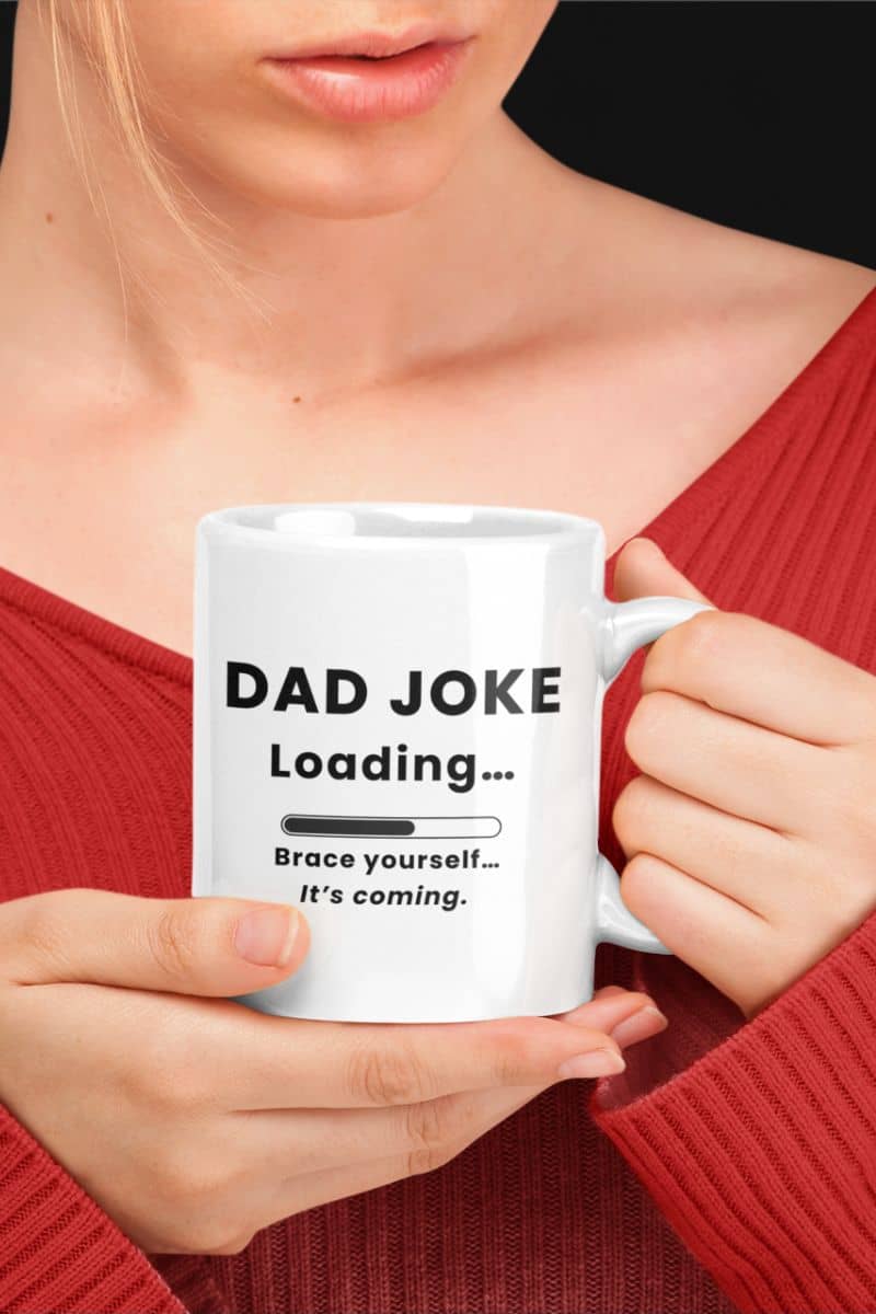 dad joke loading mug with a person holding a white mug with 'Dad Joke Loading, Brace yourself…It’s coming.' text design.