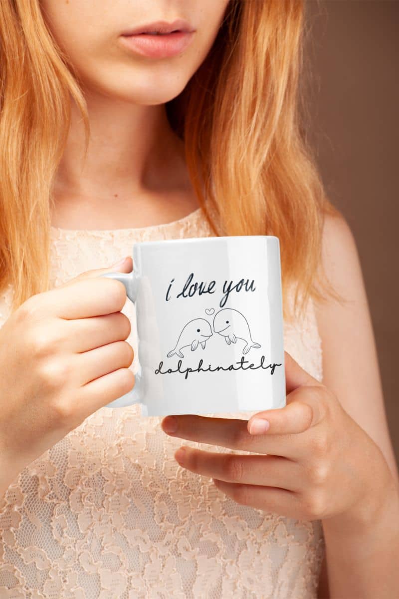 dolphinately mug with a person holding a mug with 'I love you dolphinately' text and dolphin illustration.