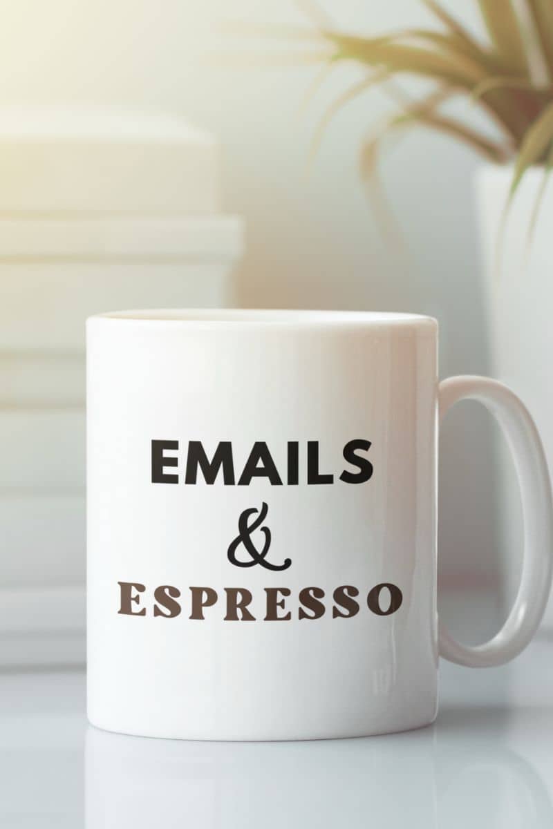 espresso mug with a white mug with text 'EMAILS & ESPRESSO' on a blurred background