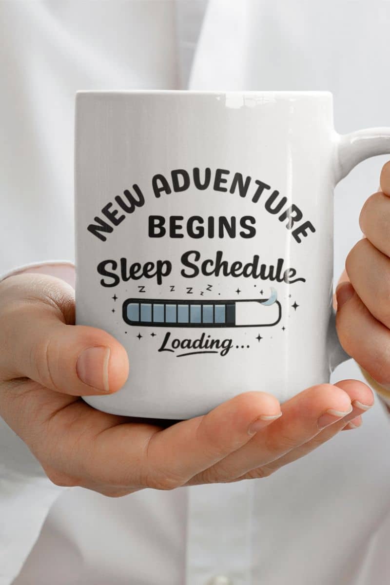 exhausted coffee mug with a person holding a white mug with text 'New Adventure Begins, Sleep Schedule Loading…'