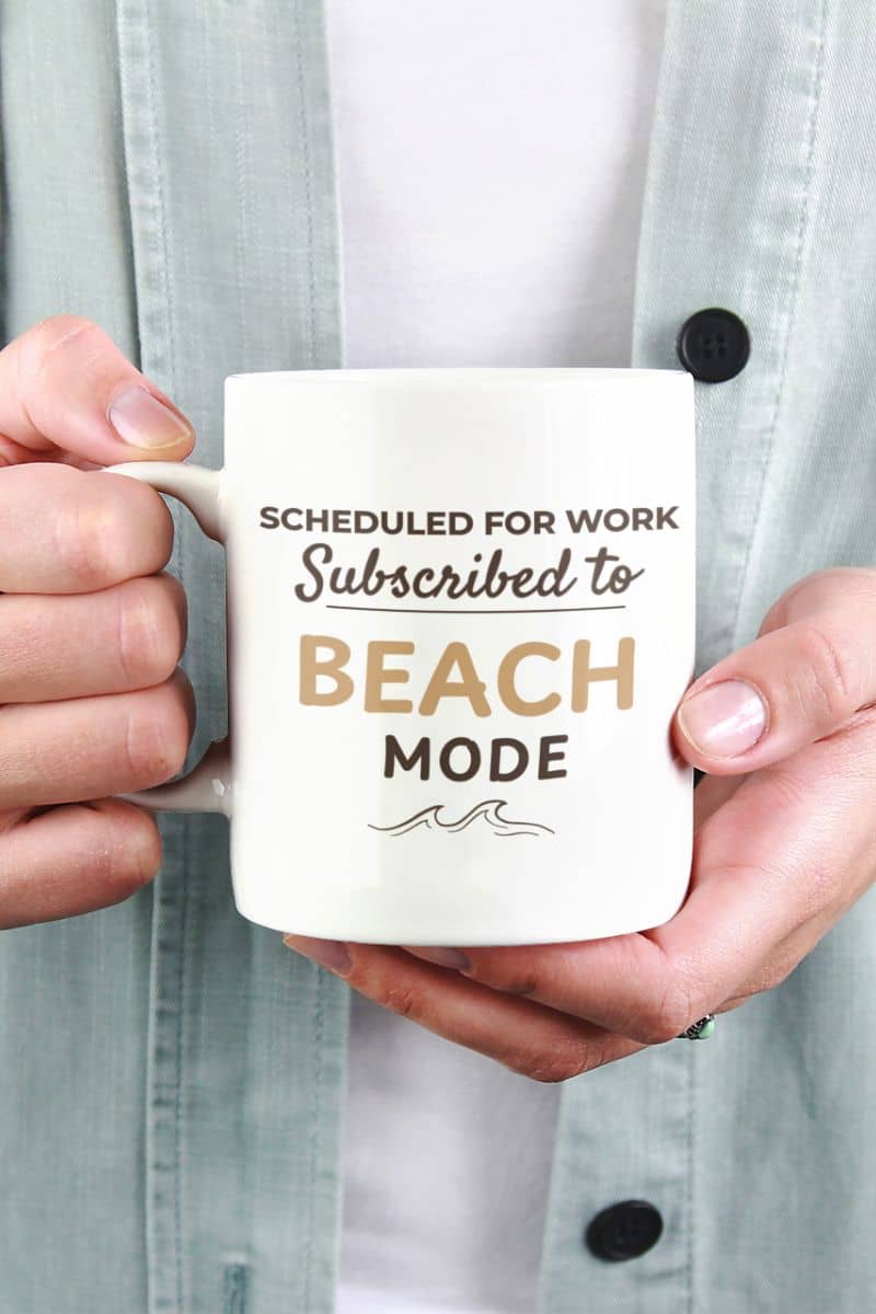 funny beach mug with a person holding a mug with text 'Scheduled for work. Subscribed to beach mode'.