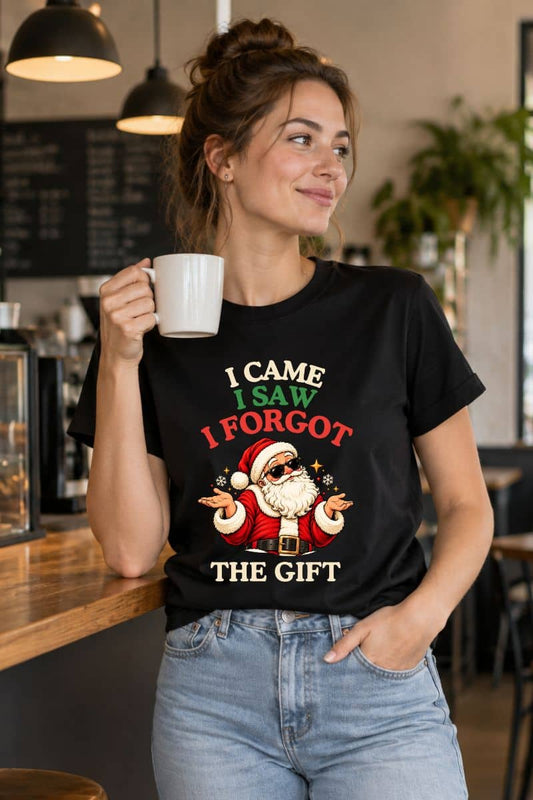 Funny Christmas shirts collection featuring a black tee with the quote “I Came. I Saw. I Forgot the Gift,” modeled by a woman holding a white mug in a café.