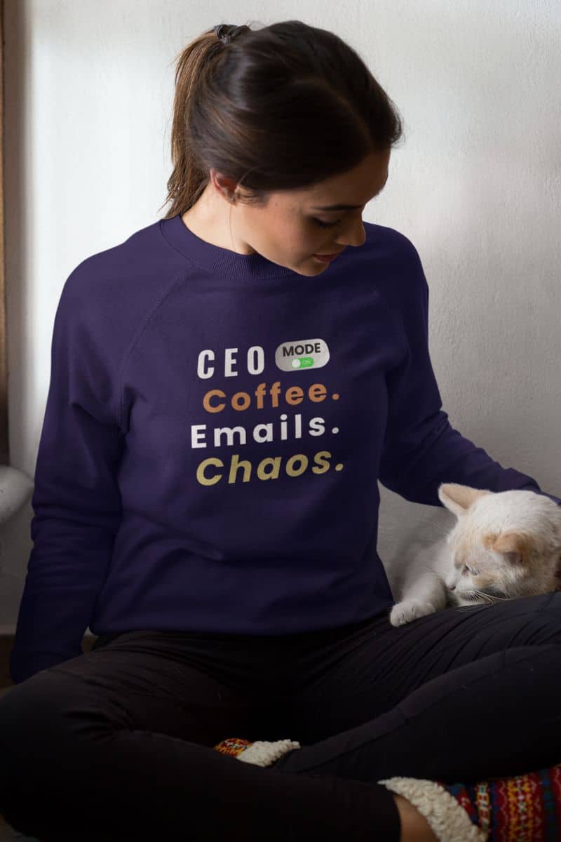A funny coworker sweatshirt with a woman in a purple sweatshirt with text 'CEO Mode: Coffee. Emails. Chaos.'