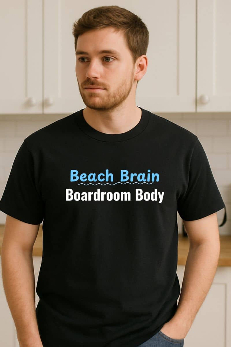 funny coworker t-shirt with a man wearing a black t-shirt with 'Beach Brain Boardroom Body' text in a kitchen setting