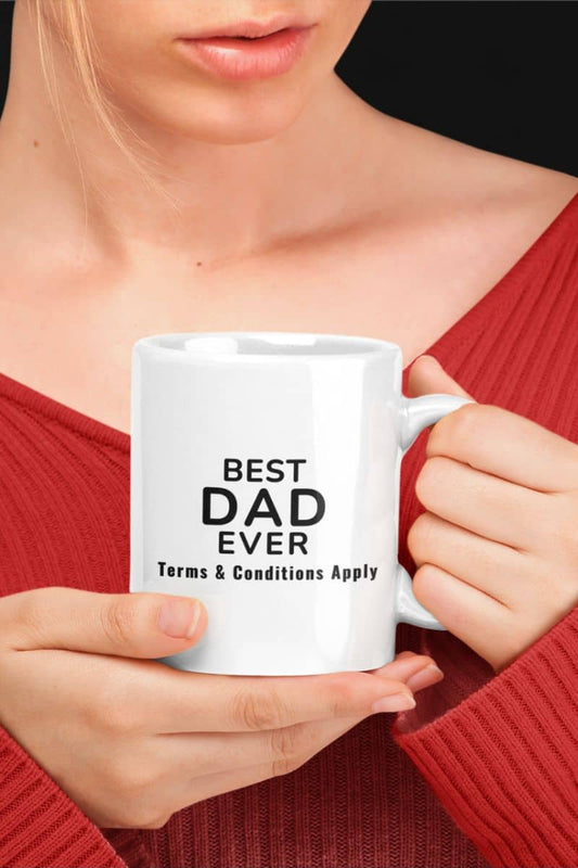 funny dad mugs with a person holding a white mug with 'Best Dad Ever. Terms & Conditions Apply' text, wearing a red sweater.