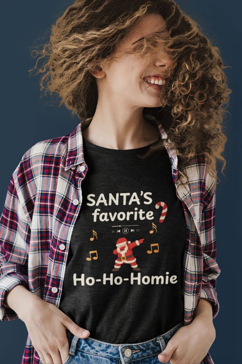 funny holiday t-shirt with a person wearing a black t-shirt with Christmas-themed text and graphics, standing against a dark background.