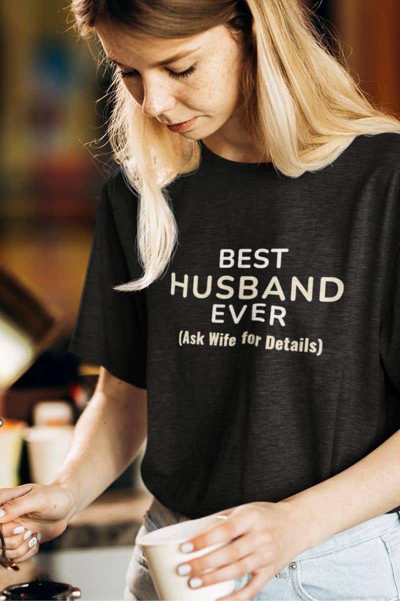 funny husband shirt with a woman wearing a black t-shirt with 'Best Husband Ever (Ask Wife for Details)' text.