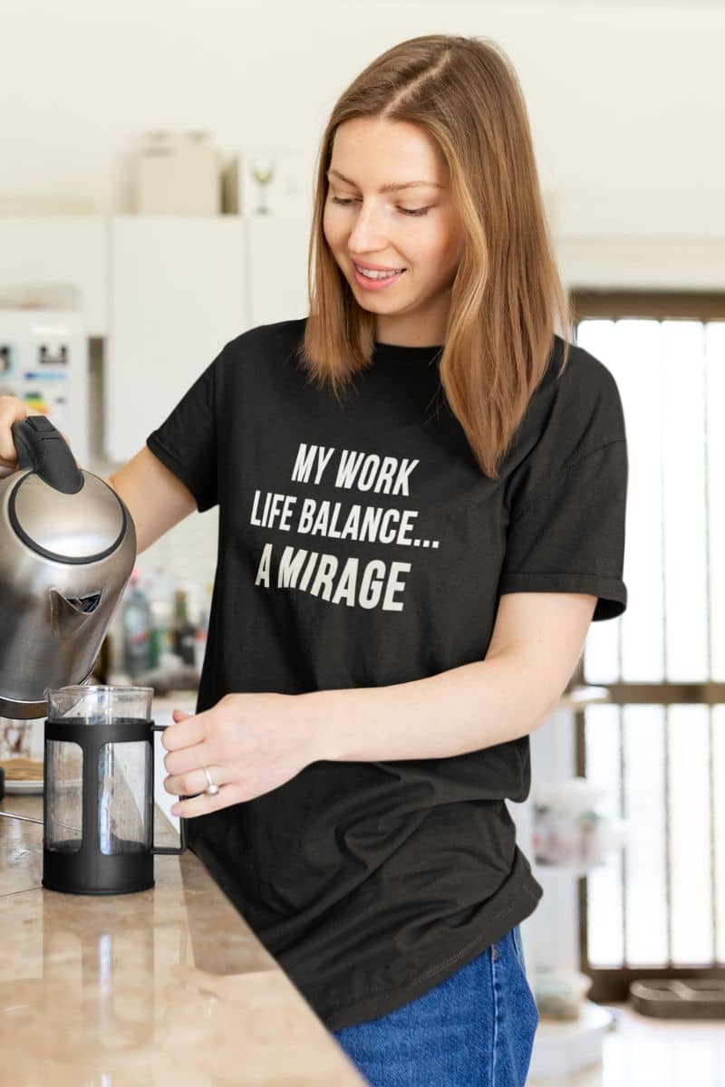 funny office shirt with a woman in a kitchen wearing a black t-shirt with text 'My Work-Life Balance Is a Mirage
