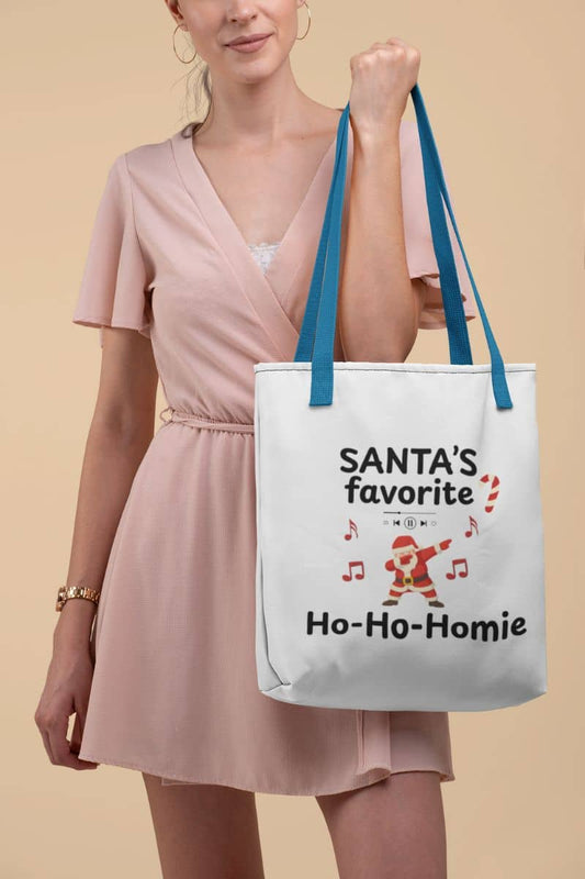 funny santa tote bag with a woman holding a tote bag with 'Santa's favorite Ho-Ho-Homie' text and design on a beige background