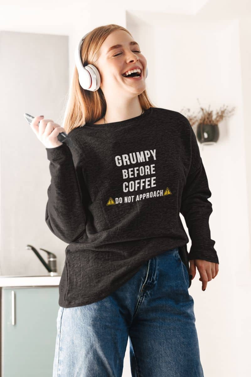 funny statement sweatshirt with a woman wearing a sweatshirt with text 'Grumpy before coffee, do not approach'