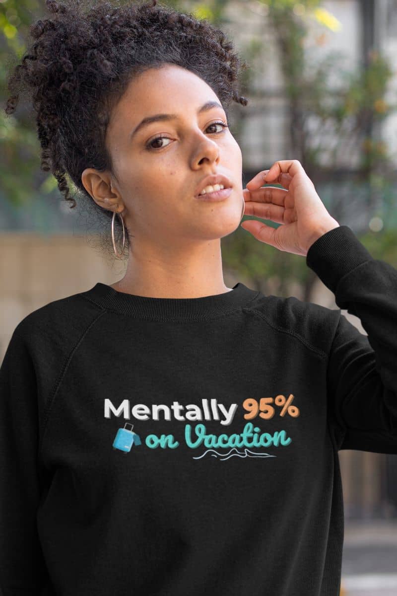 funny travel crewneck with a person wearing a black sweatshirt with text 'Mentally 95% on Vacation' outdoors.