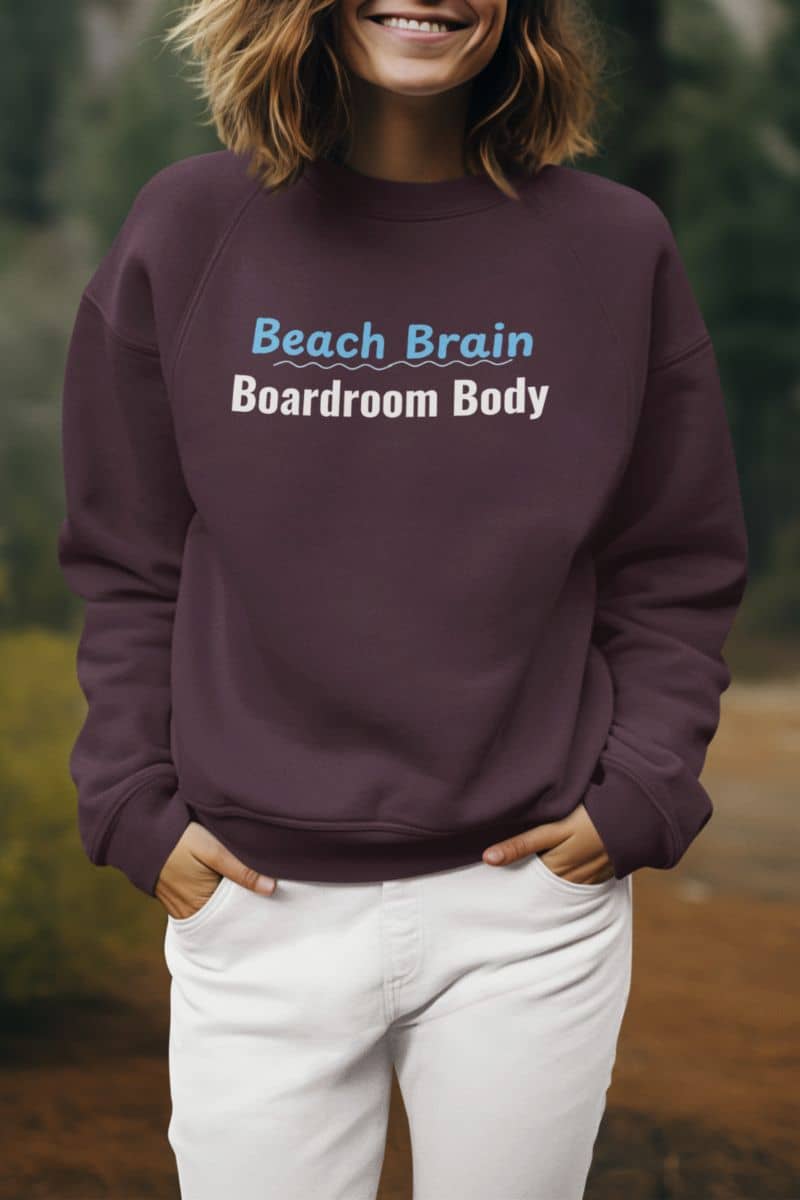 funny travel sweatshirt with a person wearing a purple sweatshirt with 'Beach Brain Boardroom Body' text, standing outdoors.