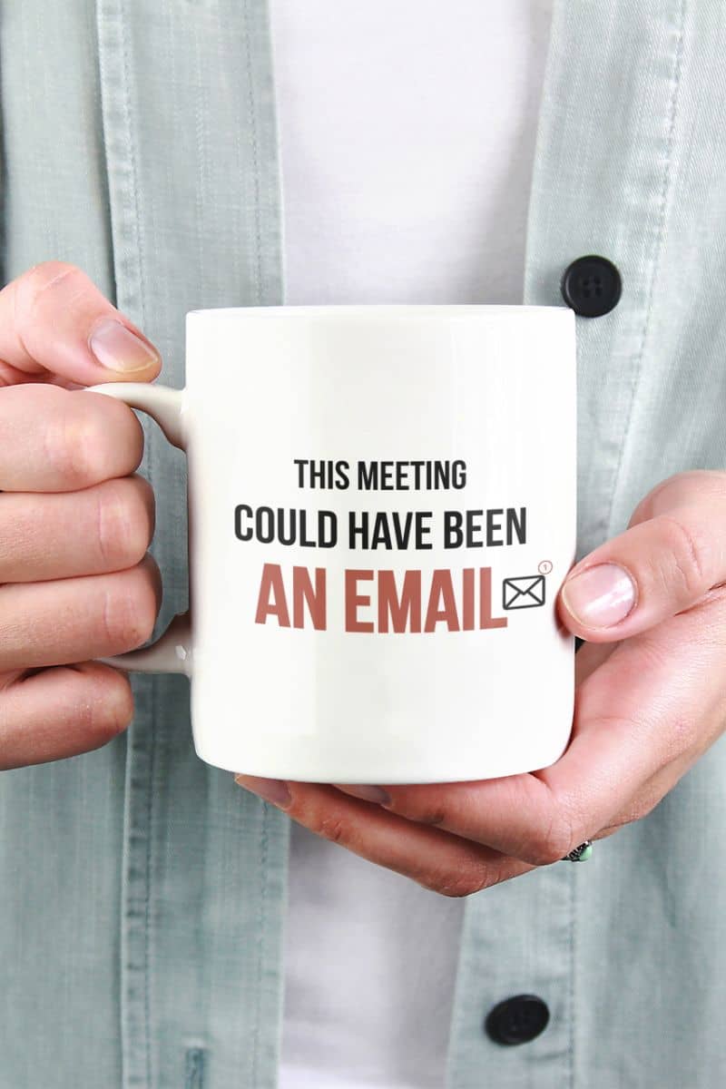 funny work mug with a person holding a mug with text 'This meeting could have been an email' against a light background