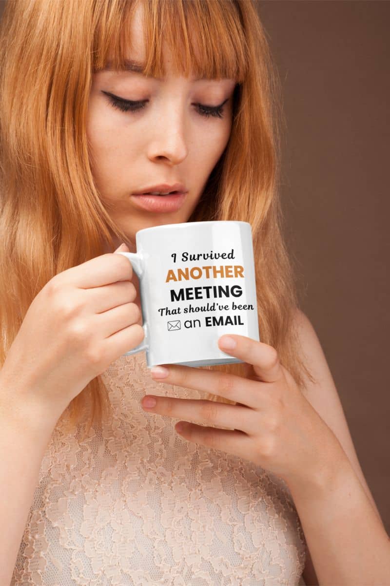 funny work mug with a woman holding a mug with text 'I Survived Another Meeting That Should’ve Been an Email' against a brown background