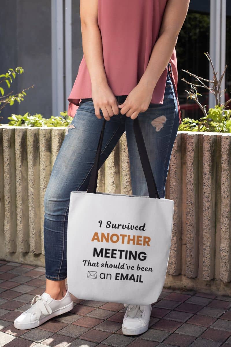 funny work tote with a person holding a tote bag with text 'Office Humor Tote – I Survived Another Meeting That Should’ve Been an Email'