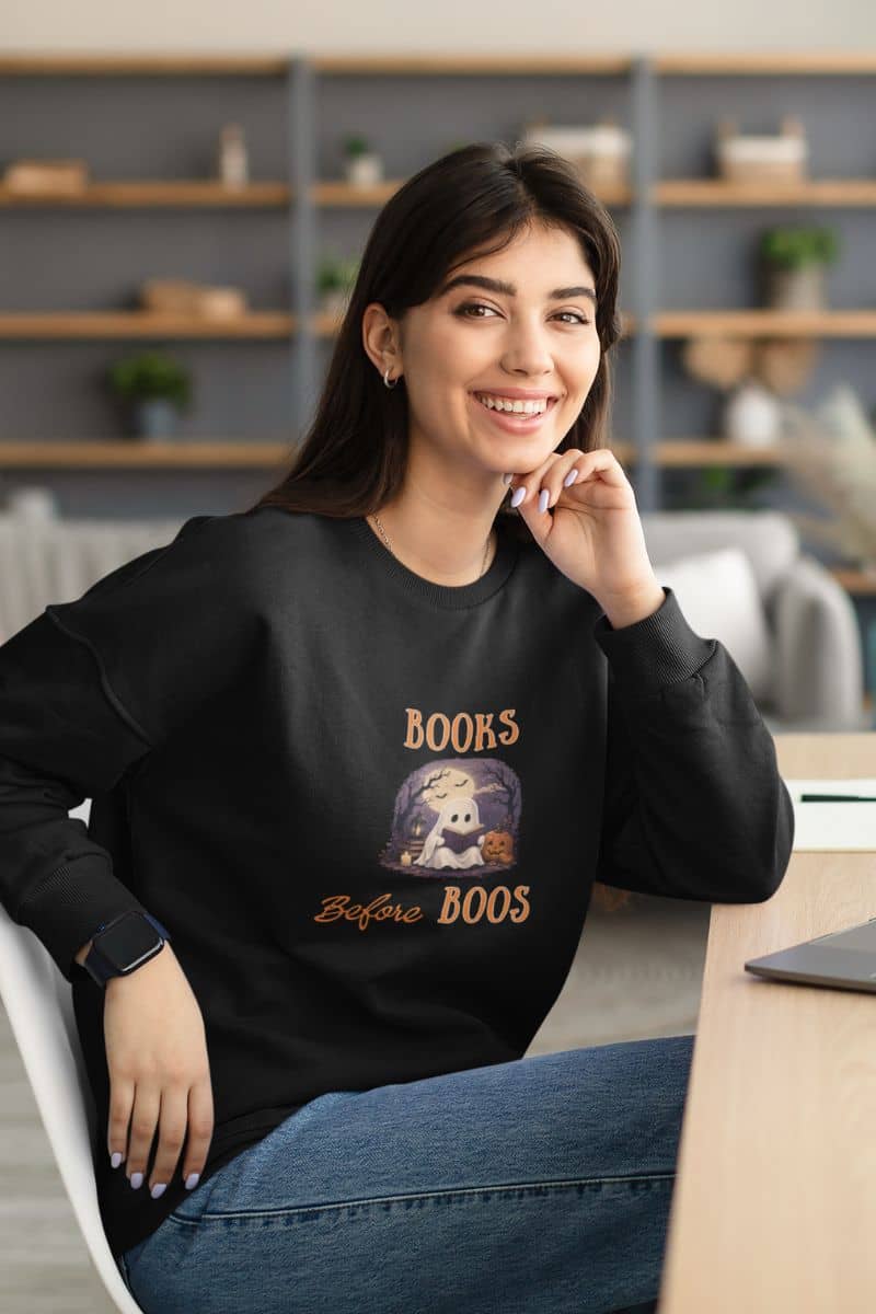 ghost book sweatshirt featuring a woman wearing a sweatshirt with text 'Books Before Boos'