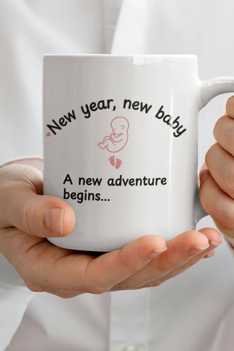 gift for expecting parents with a person holding a mug with text 'New year, new baby. A new adventure begins...'