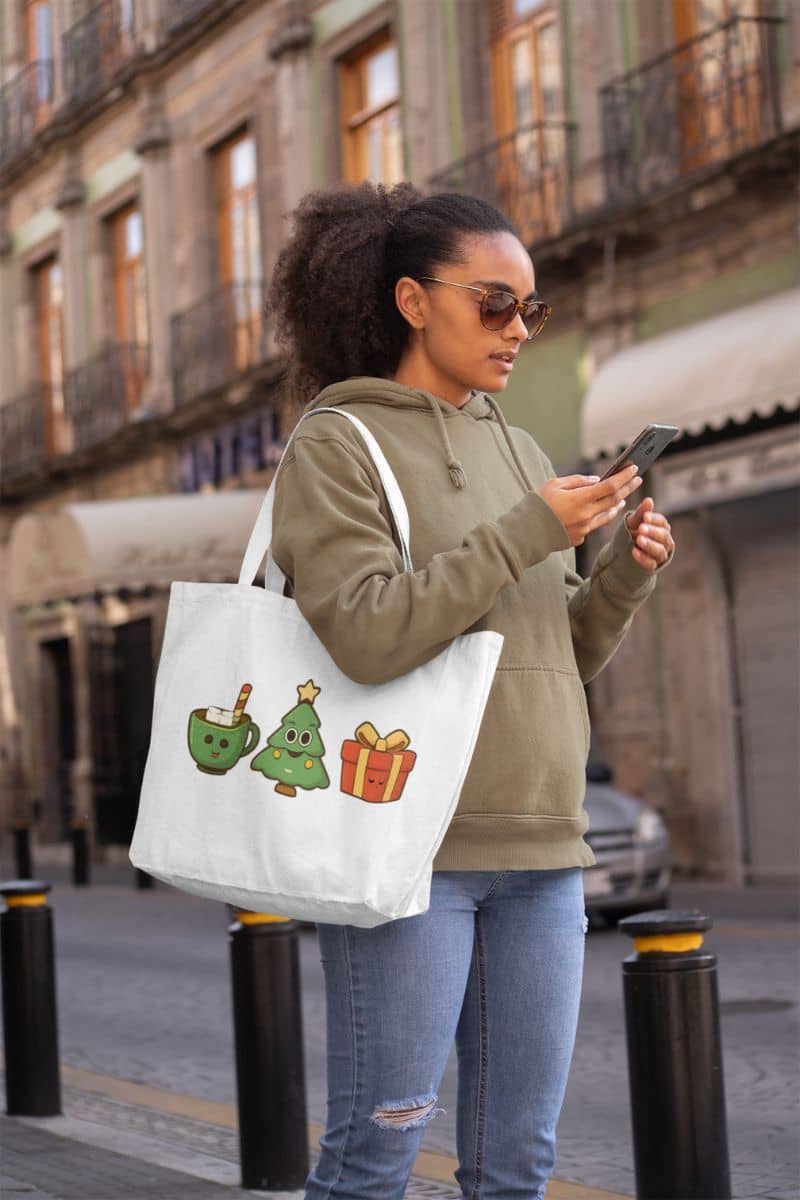 gift idea holiday tote with a woman holding a phone and a tote bag with Christmas-themed designs on a city street.