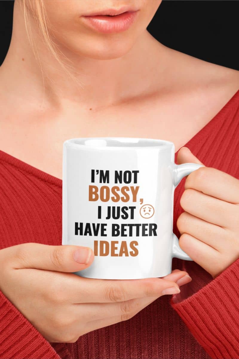 girl boss coffee mug with a person holding a mug with text 'I'm not bossy, I just have better ideas' in a casual setting.