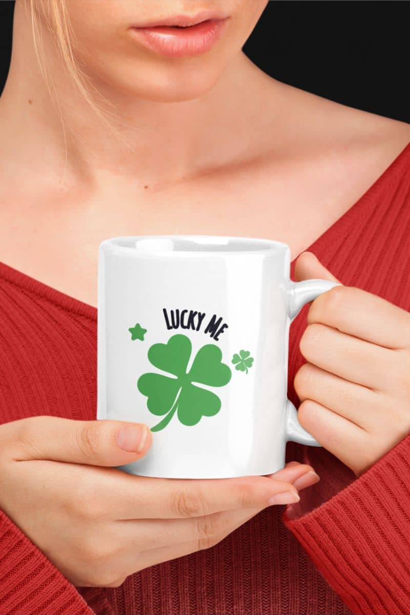 good luck mug gift with a person holding a white mug with a green four-leaf clover design and 'Lucky Me' text.