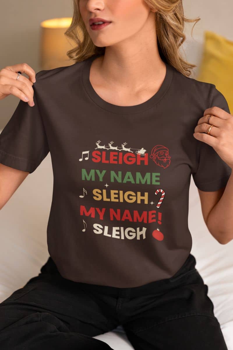 holiday funny t-shirt with a person wearing a brown t-shirt with text 'Sleigh My Name, Sleigh My Name' and graphics.
