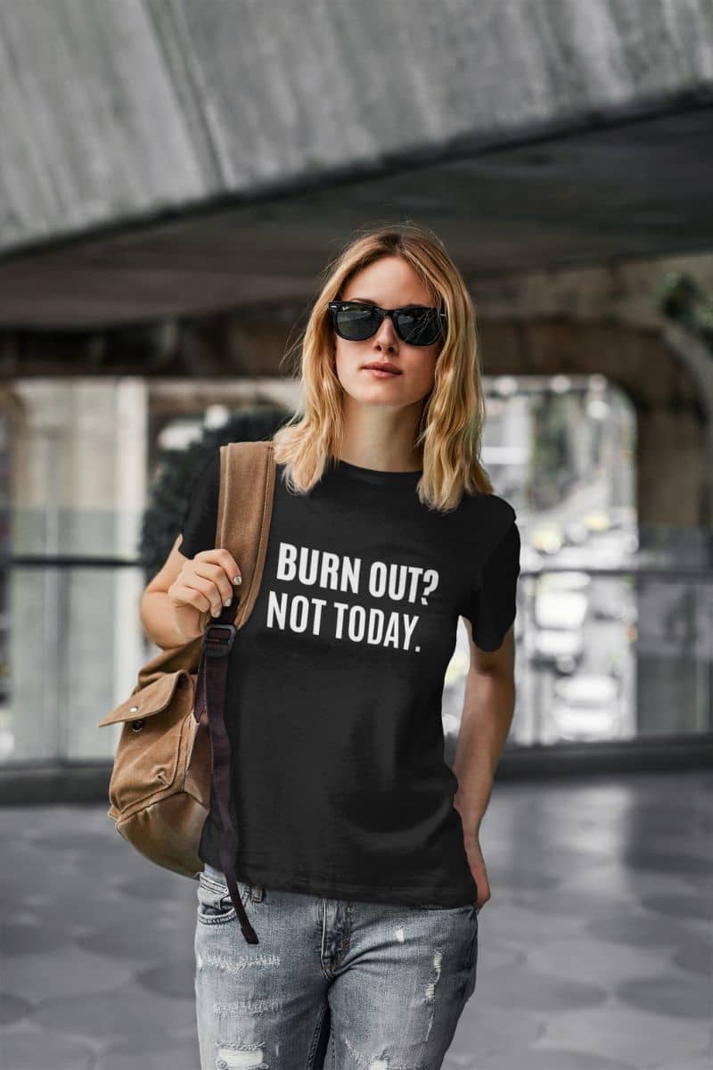 inspirational quote tee with a person wearing a black t-shirt with 'BURN OUT? NOT TODAY.' text, holding a brown bag.
