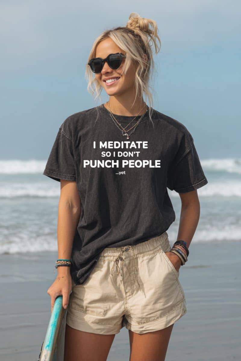 introvert t-shirt with a woman on a beach wearing a t-shirt with text 'I Meditate So I Don’t Punch People...yet'