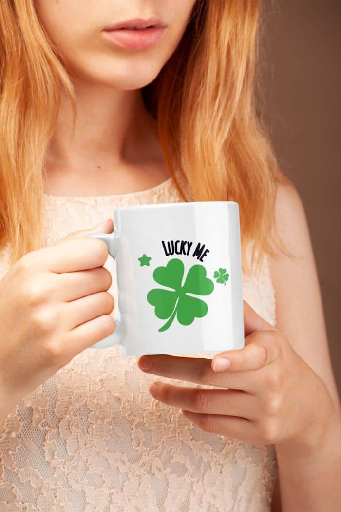 lucky coffee mug with a person holding a mug with a four-leaf clover design and 'Lucky Me' text.