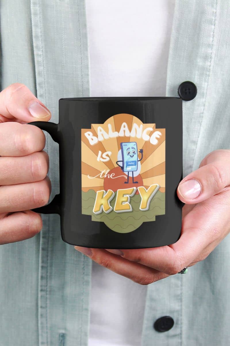 mindfulness coffee mug with a person holding a black mug with 'Balance is the Key' design.