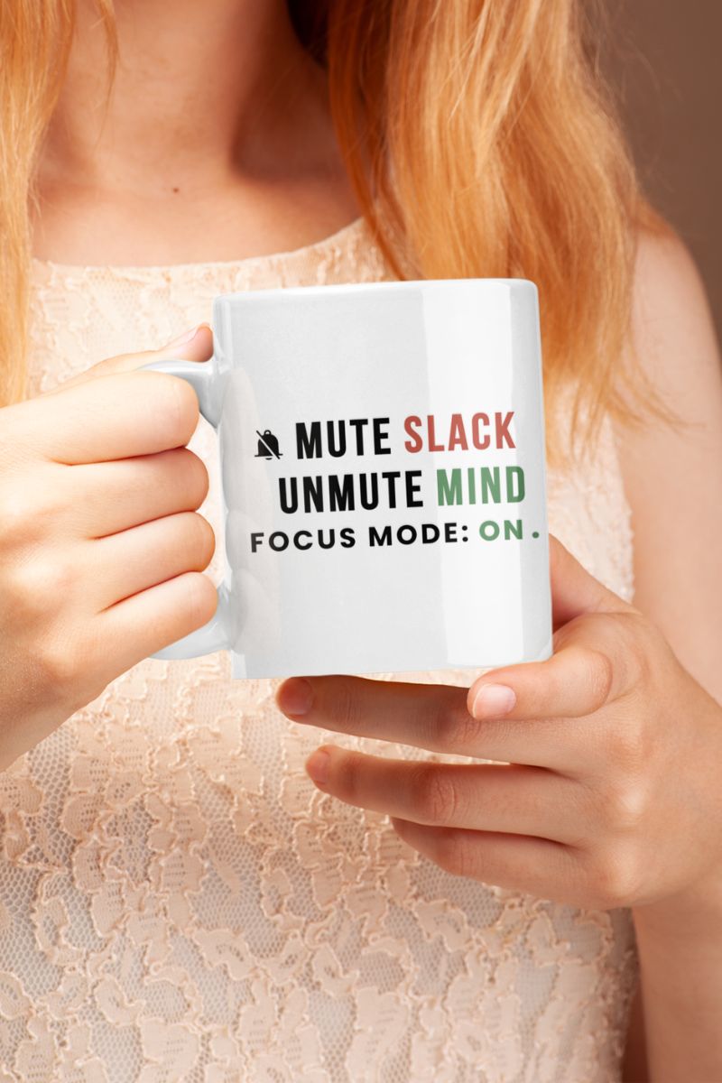 mindfulness coffee mug with a person holding a mug with text 'Mute Slack, Unmute Mind, Focus Mode: On' against a neutral background