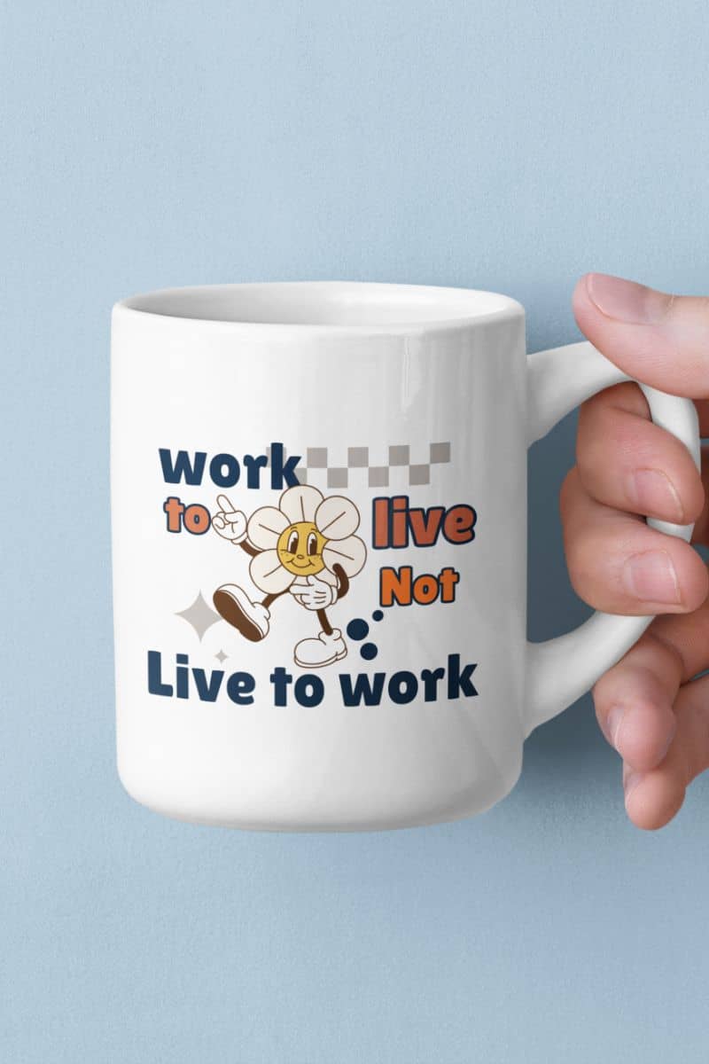 mindfulness tea cup with a mug with text 'Work to Live, Not Live to Work' and cartoon character held by a hand against a light blue background