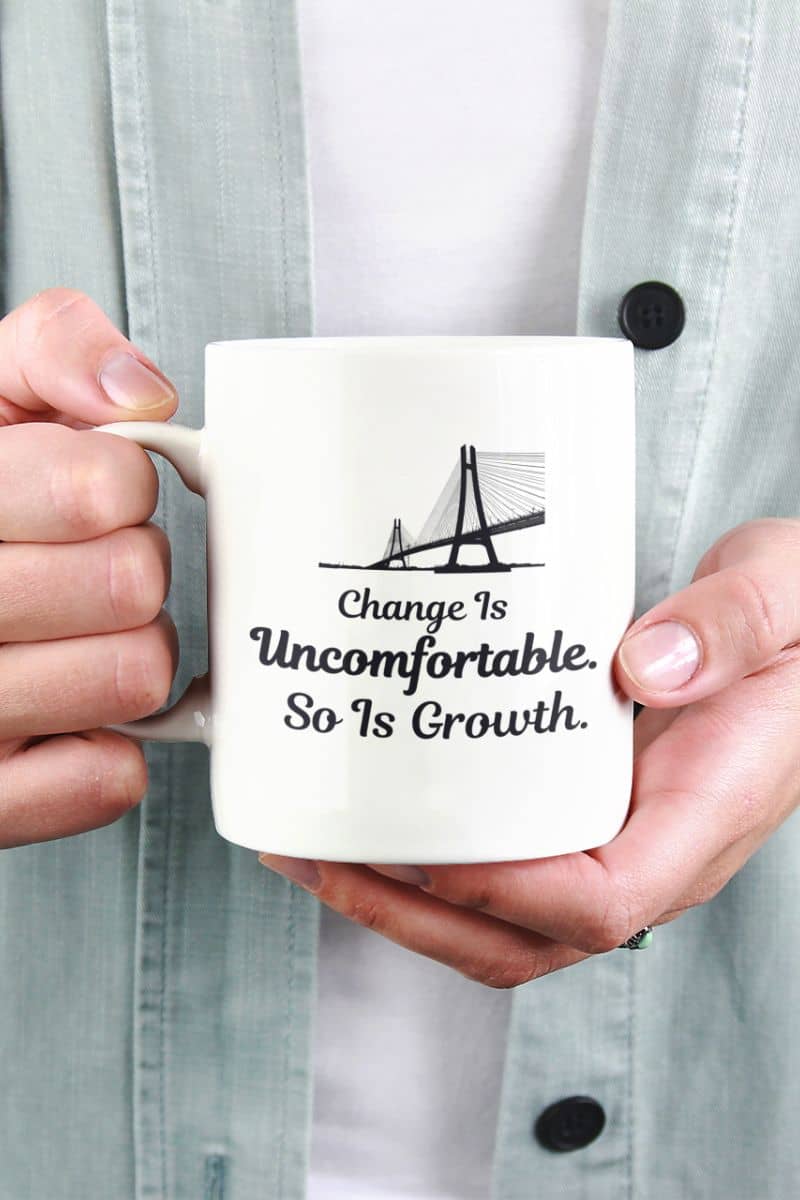 mindset coffee mug with a person holding a mug with a motivational quote 'Change Is Uncomfortable. So Is Growth' on it.