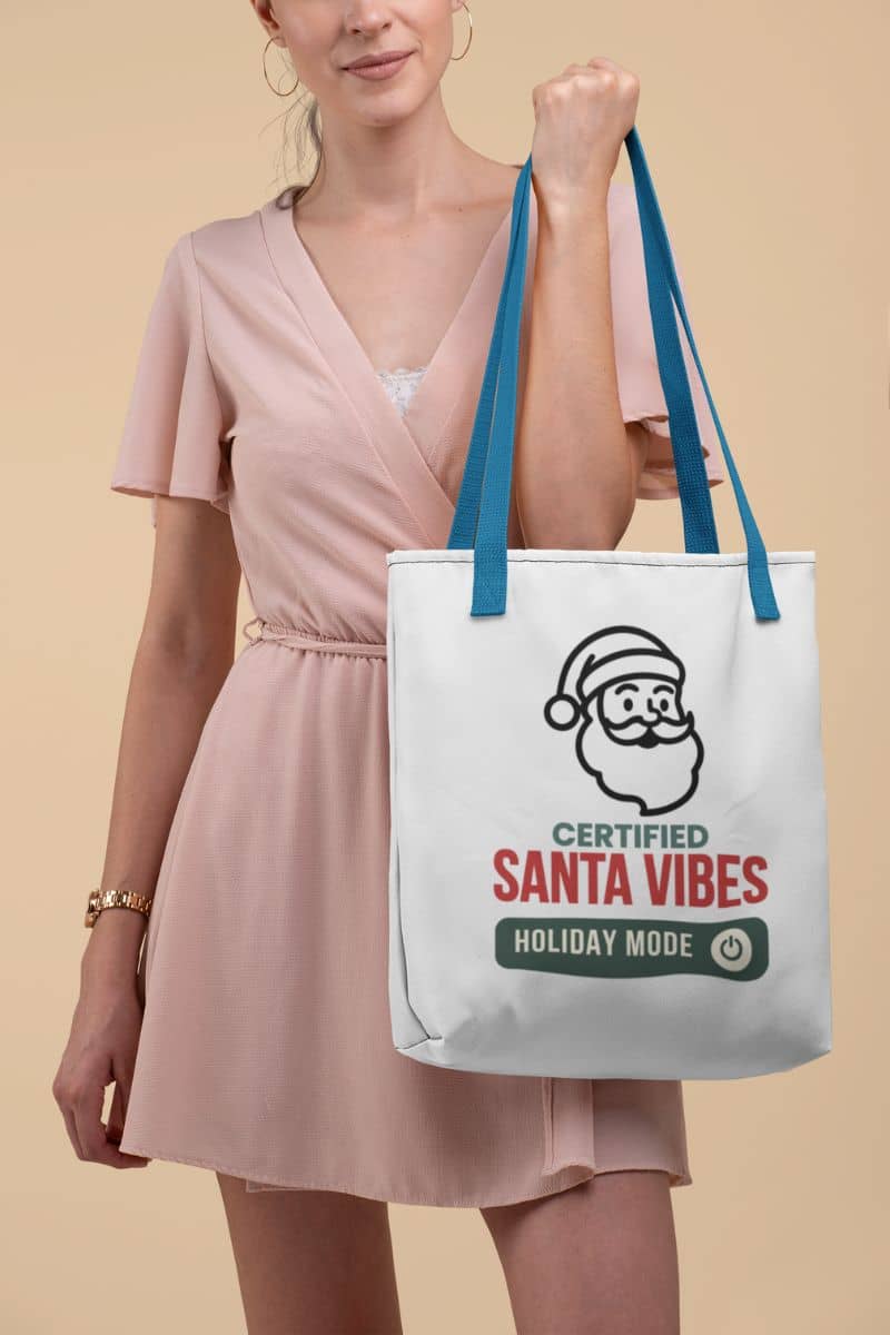 minimalist holiday tote with a woman holding a tote bag with 'Certified Santa Vibes – Holiday Mode On' text against a beige background