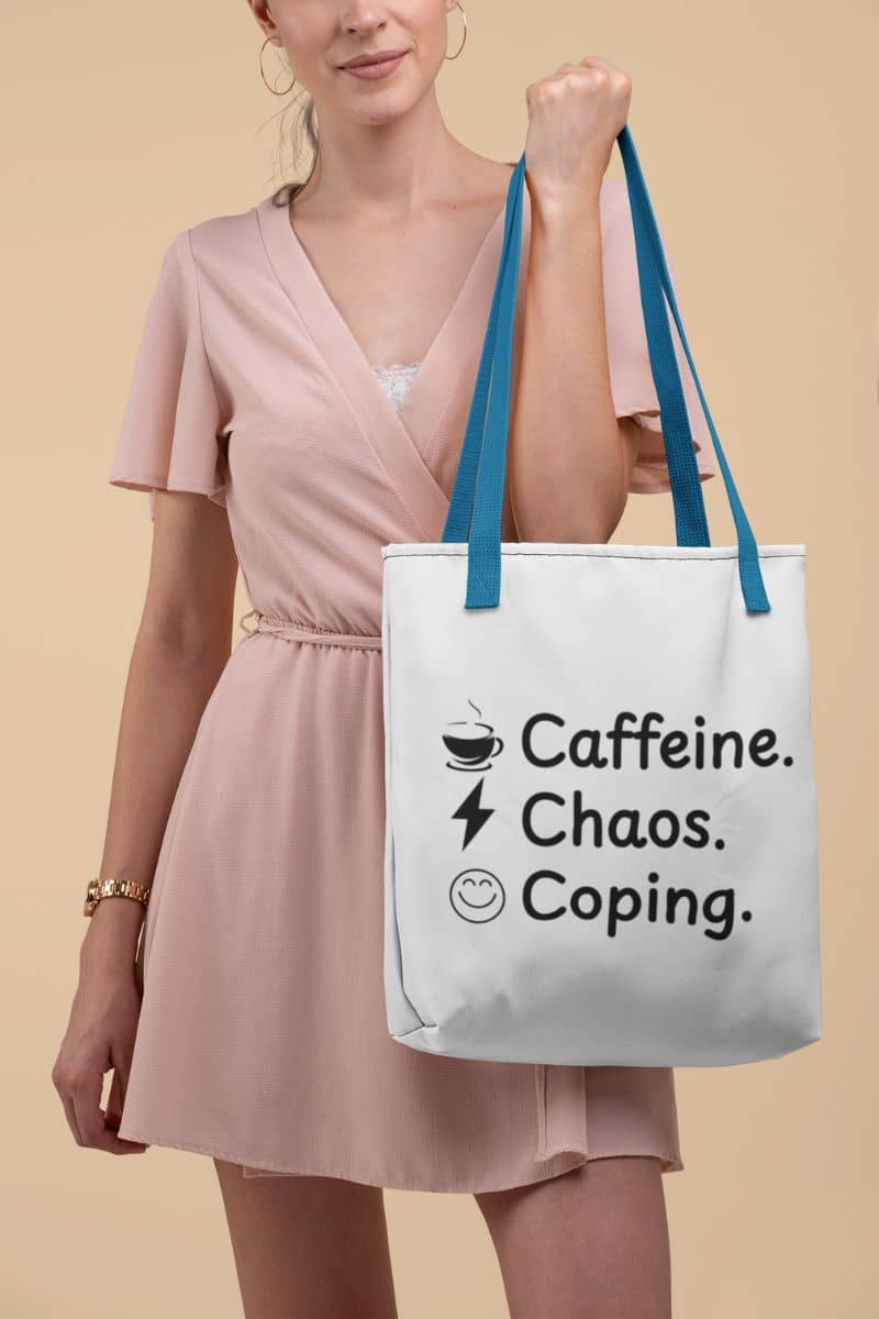 minimalist tote bag with a woman holding a tote bag with 'Caffeine. Chaos. Coping.' text on a beige background