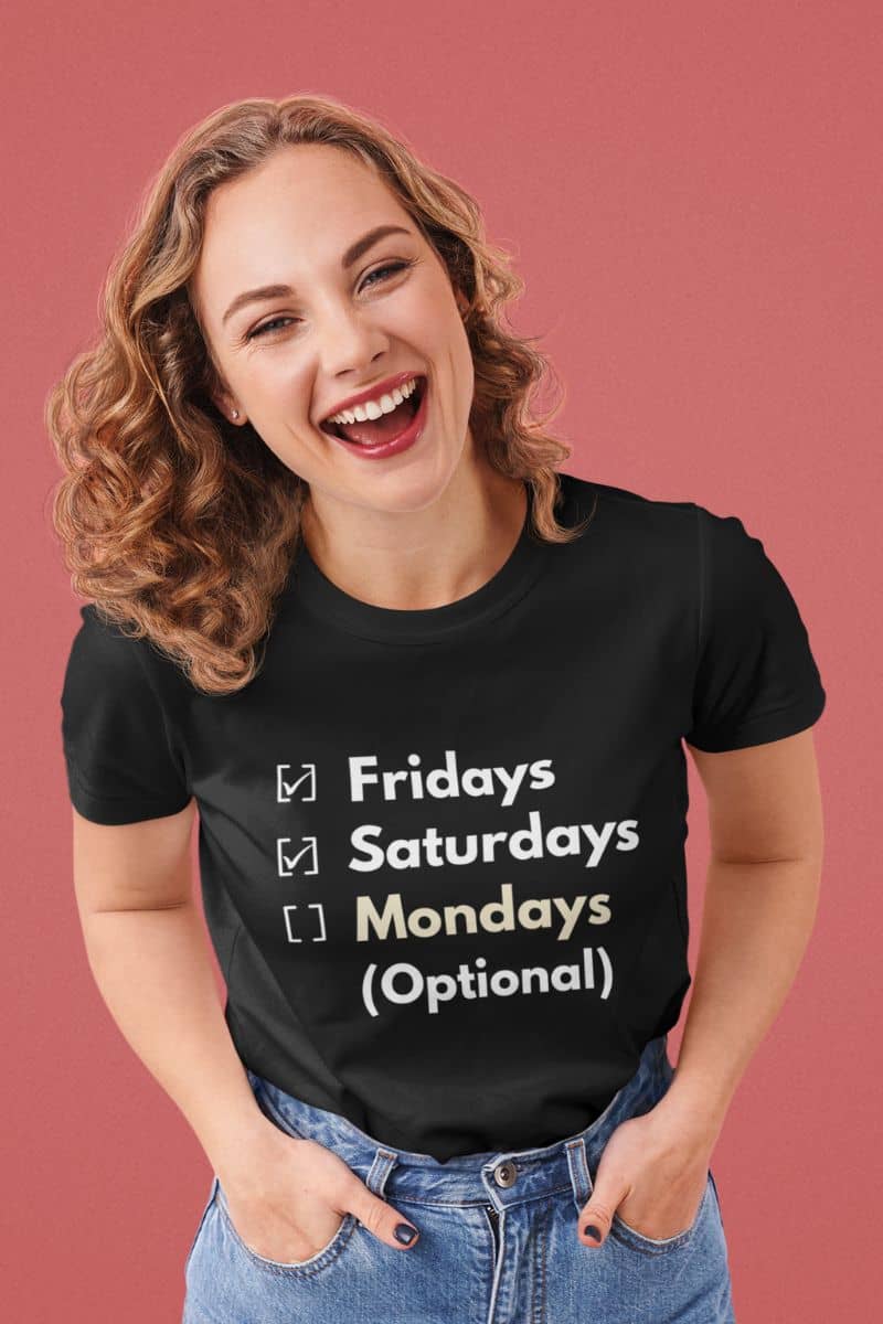 modern office humor tee with a woman wearing a black t-shirt with text  'Fridays and Saturdays, Mondays (Optional)' on a pink background