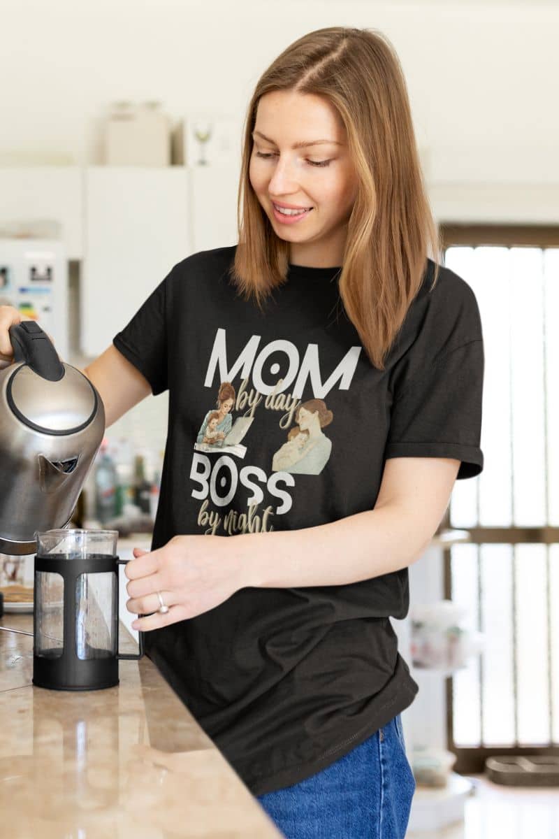 mom life t-shirt with a woman in a kitchen wearing a black t-shirt with a graphic design and text.
