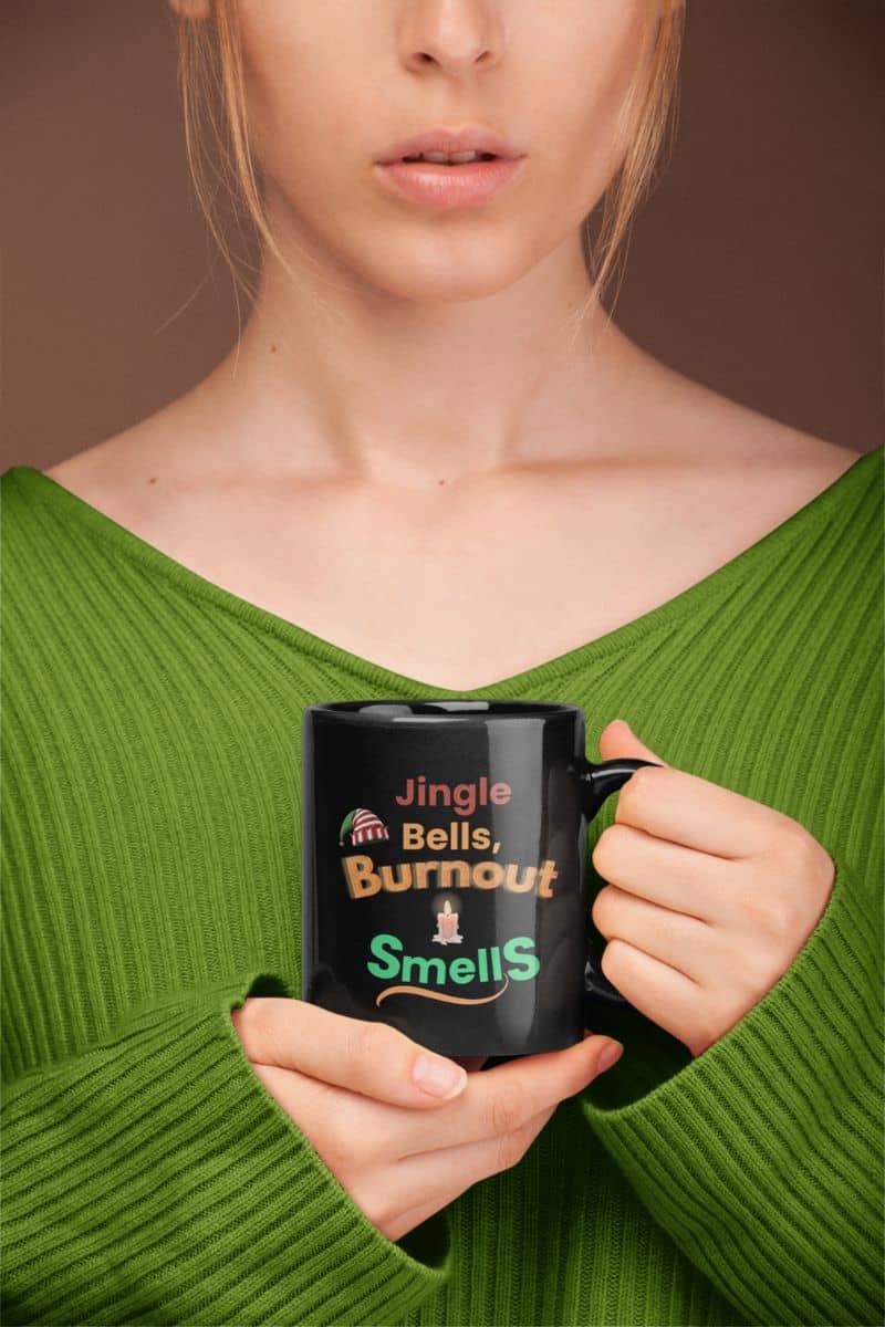 morning motivation mug with a person holding a mug with humorous text 'Jingle Bells, Burnout Smells' against a brown background