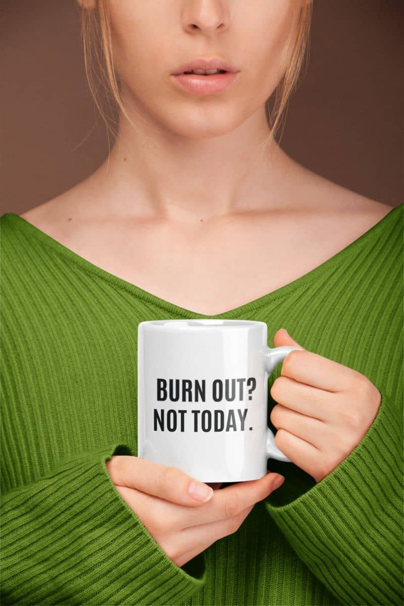 motivational office mug with a person holding a mug with 'BURN OUT? NOT TODAY.' text against a brown background