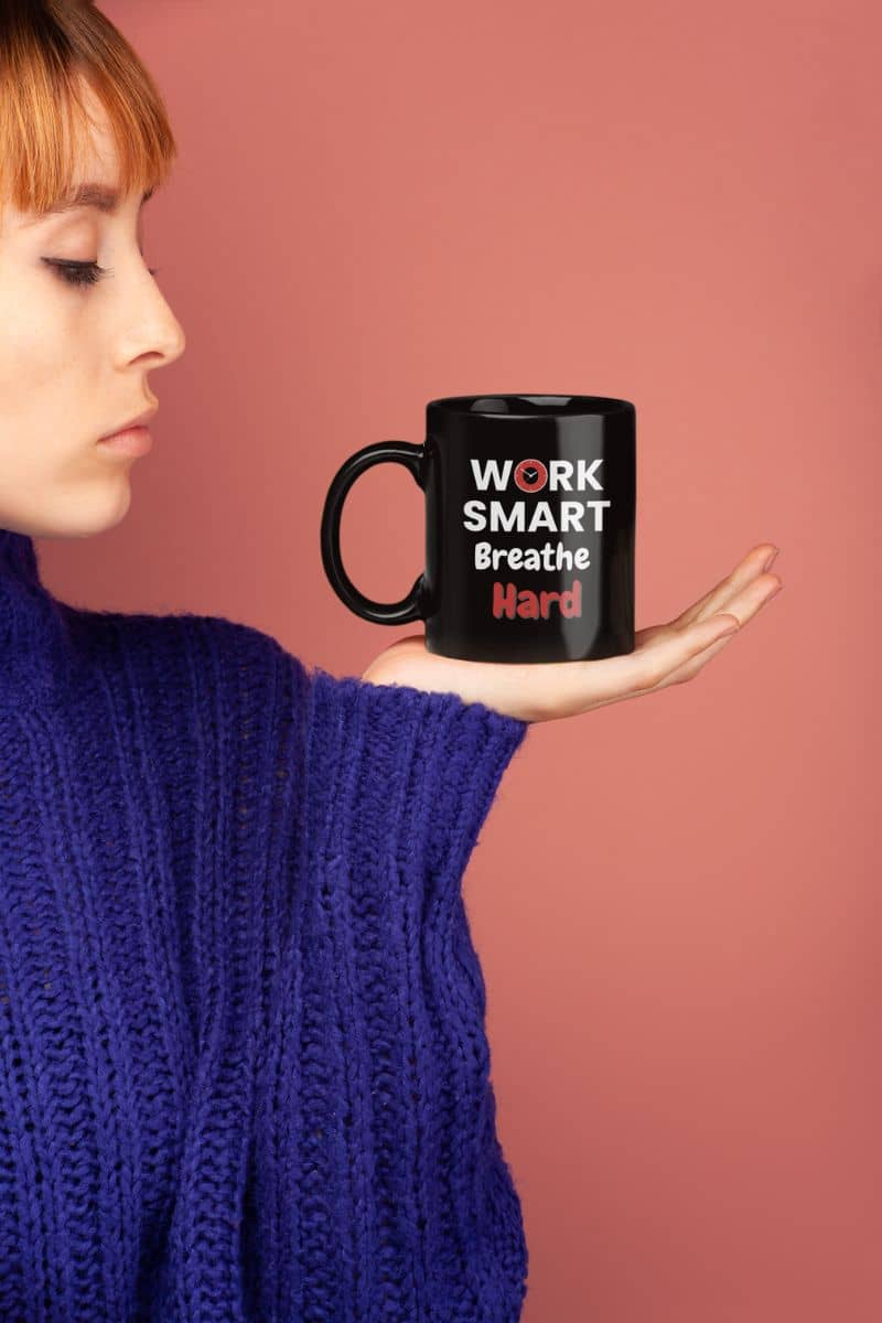 motivational sarcasm mug with a person holding a black mug with 'WORK SMART Breathe HARD' text against a pink background