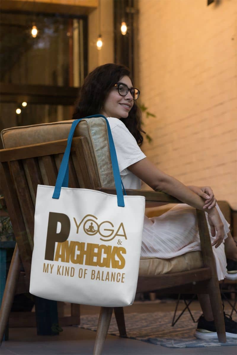 motivational tote bag for women with a woman sitting on a chair with a tote bag featuring 'Yoga Pays Checks My Kind of Balance' text.