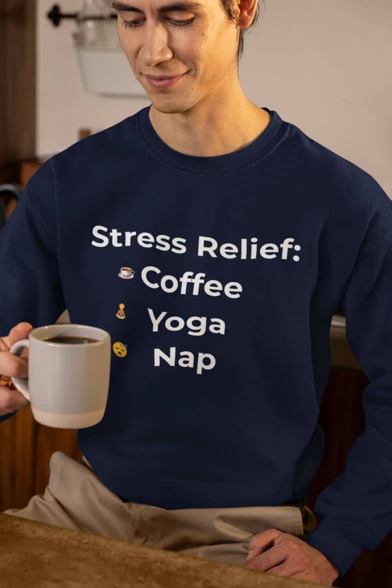 nap mode activated sweatshirt with a person wearing a navy sweatshirt with 'Stress Relief: Coffee Yoga Nap' text, holding a mug.