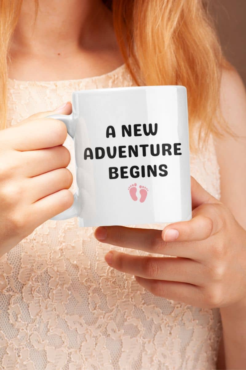 new parent mug with a person holding a mug with 'A New Adventure Begins' text and footprints.