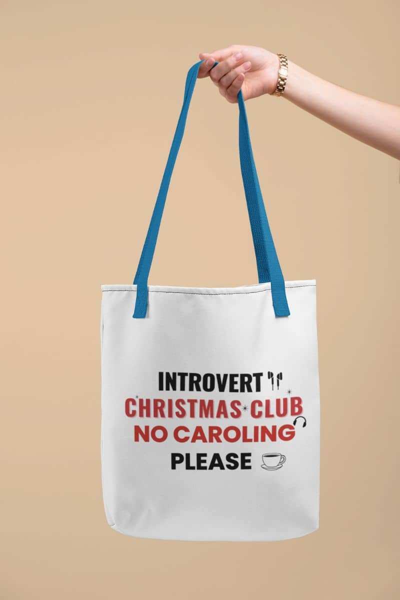 no caroling bag with a tote bag with 'Introvert Christmas Club No Caroling Please' text on a beige background