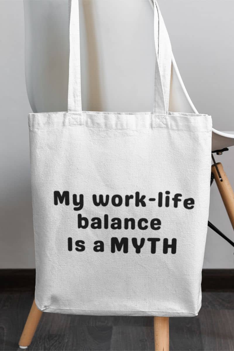office burnout bag with a white tote bag with text 'My work-life balance is a myth' on a wooden stand.