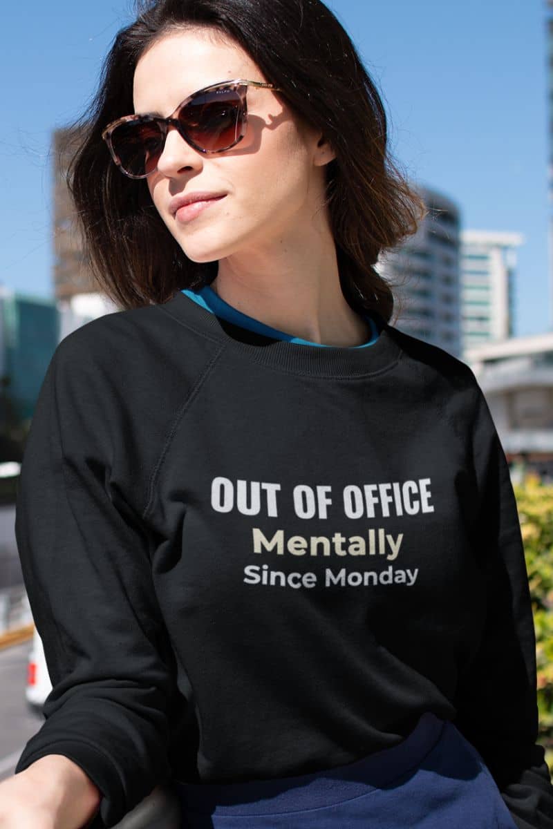 office burnout sweatshirt with a woman wearing a sweatshirt featuring the text 'Out of Office. Mentally Since Monday.'