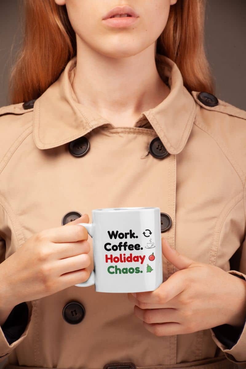 office christmas coffee mug with a person holding a mug with text 'Work. Coffee. Holiday. Chaos.' in a beige coat.