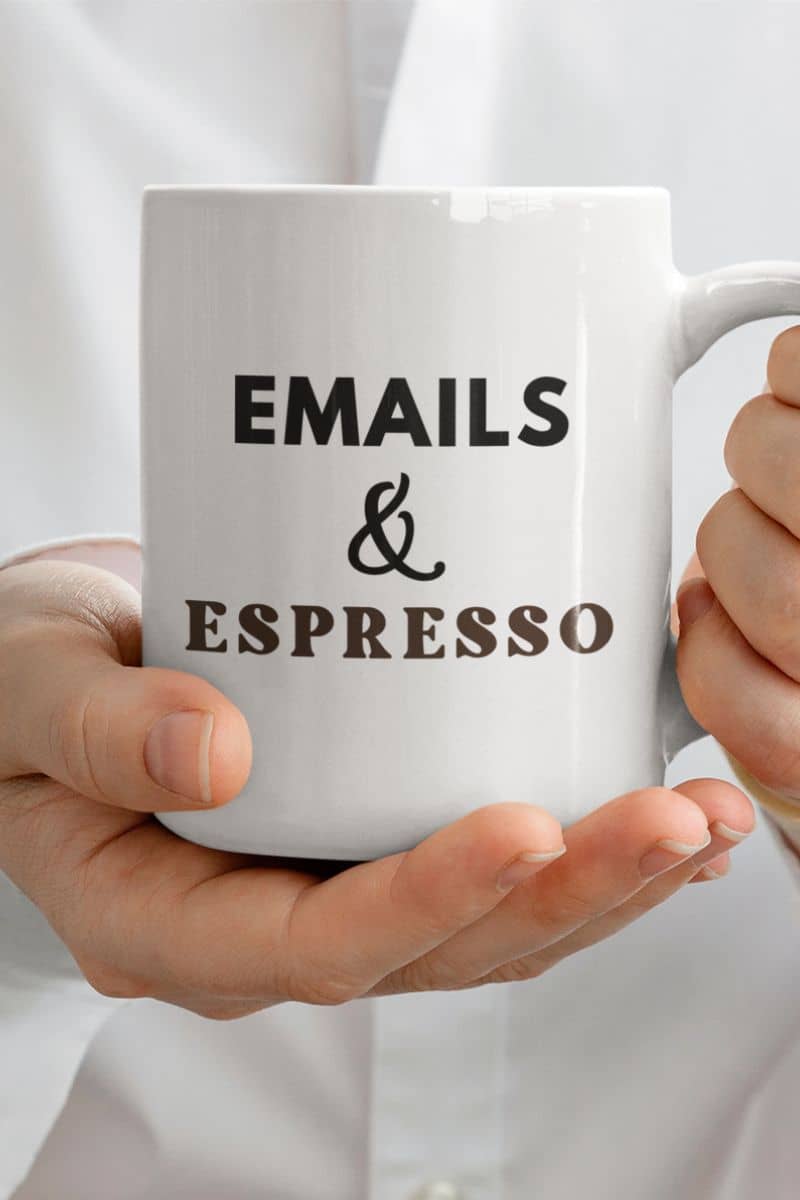 office coffee mug with a white mug with  text 'EMAILS & ESPRESSO' held by hands against a white background